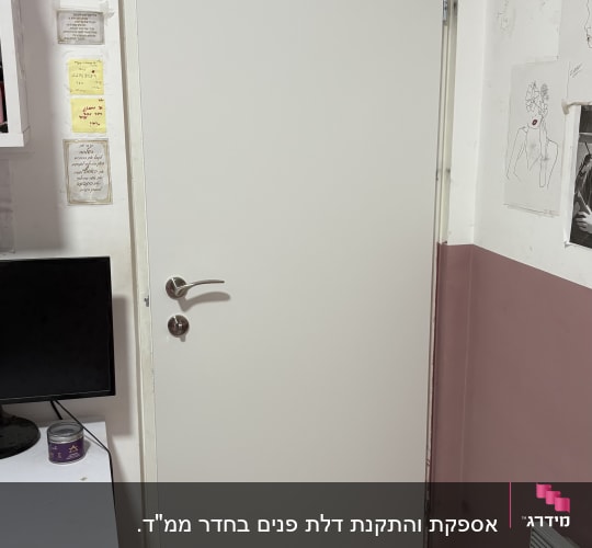 דלת לבנה עם ידית מתכת בחדר פנימי